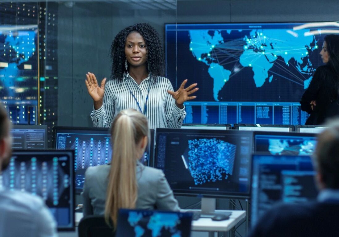Two professionals analyze global data in a high-tech control room.